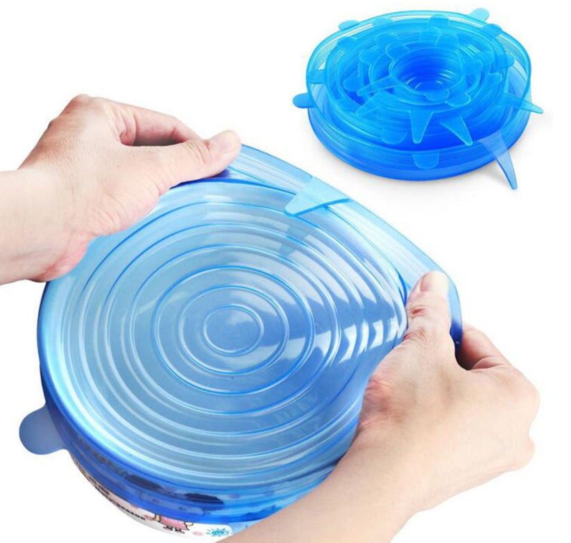 Blue silicone lid being stretched over a container by hands on a white background